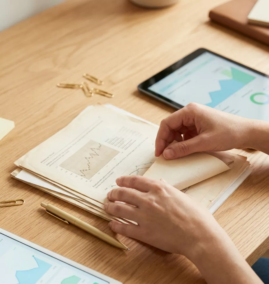 Haende ordnen Depot-Unterlagen und Tablet – Anleihen als Teil einer Struktur