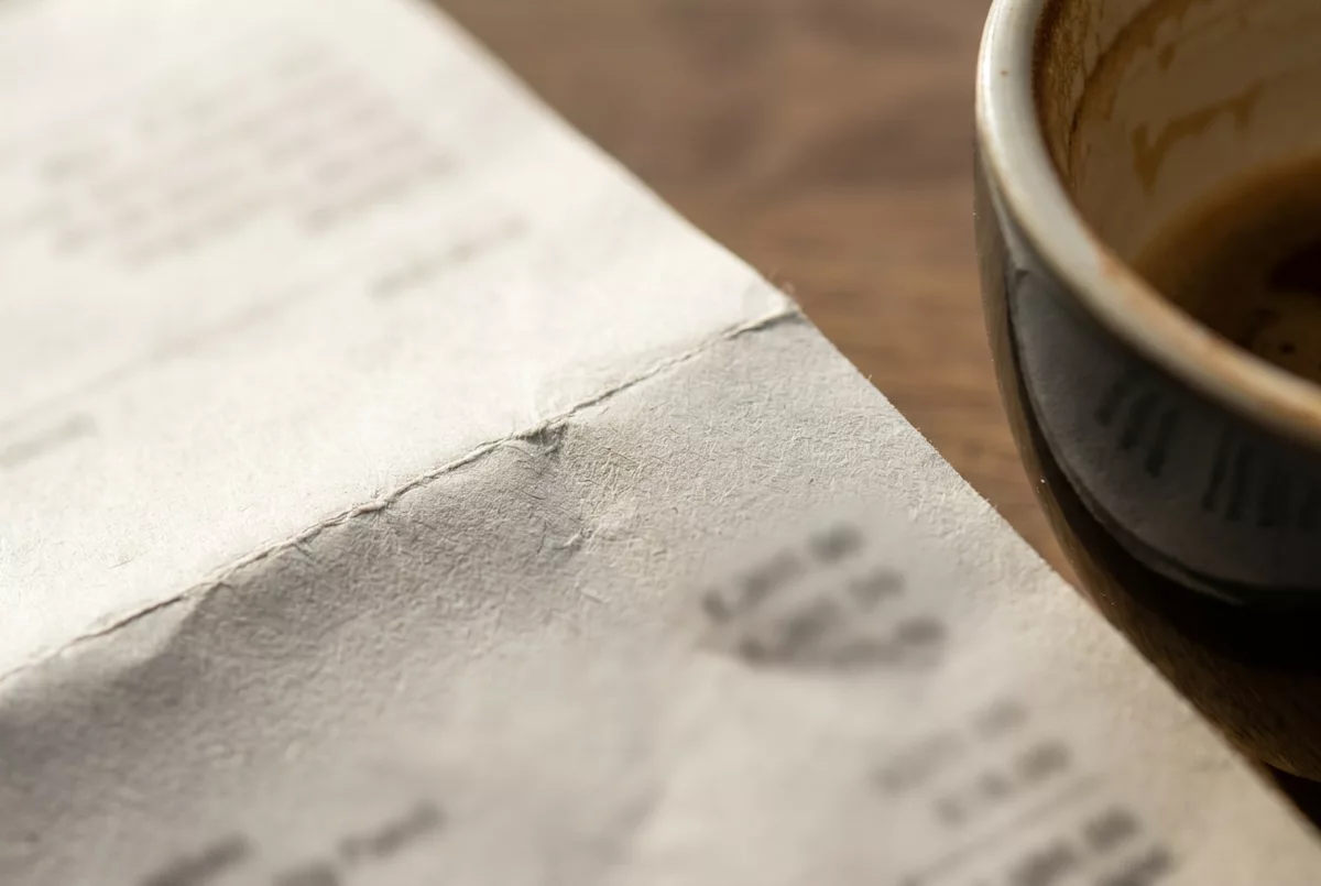 Gefaltete Jahresmitteilung neben einer Kaffeetasse auf dem Kuechentisch