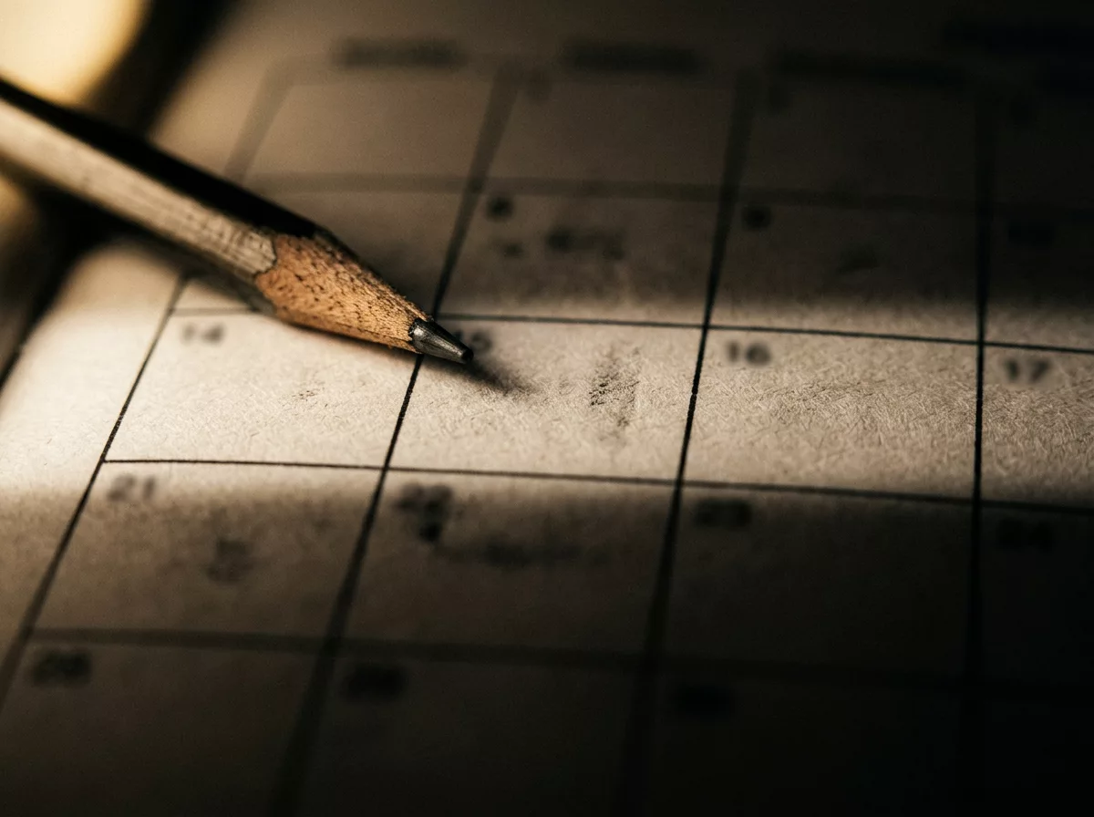 Makroaufnahme eines Kalenderrasters mit einem Bleistift darauf