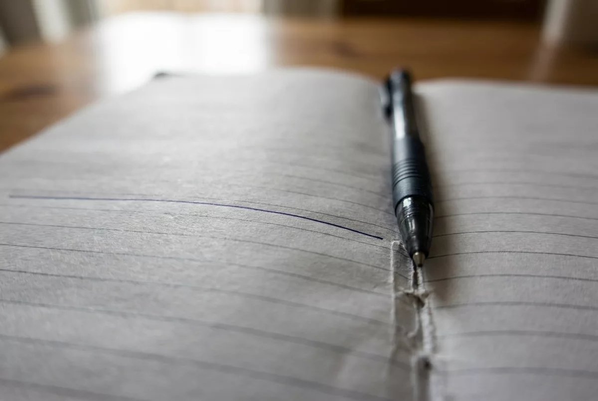 Linierter Notizblock mit Stift und einer gezogenen Linie