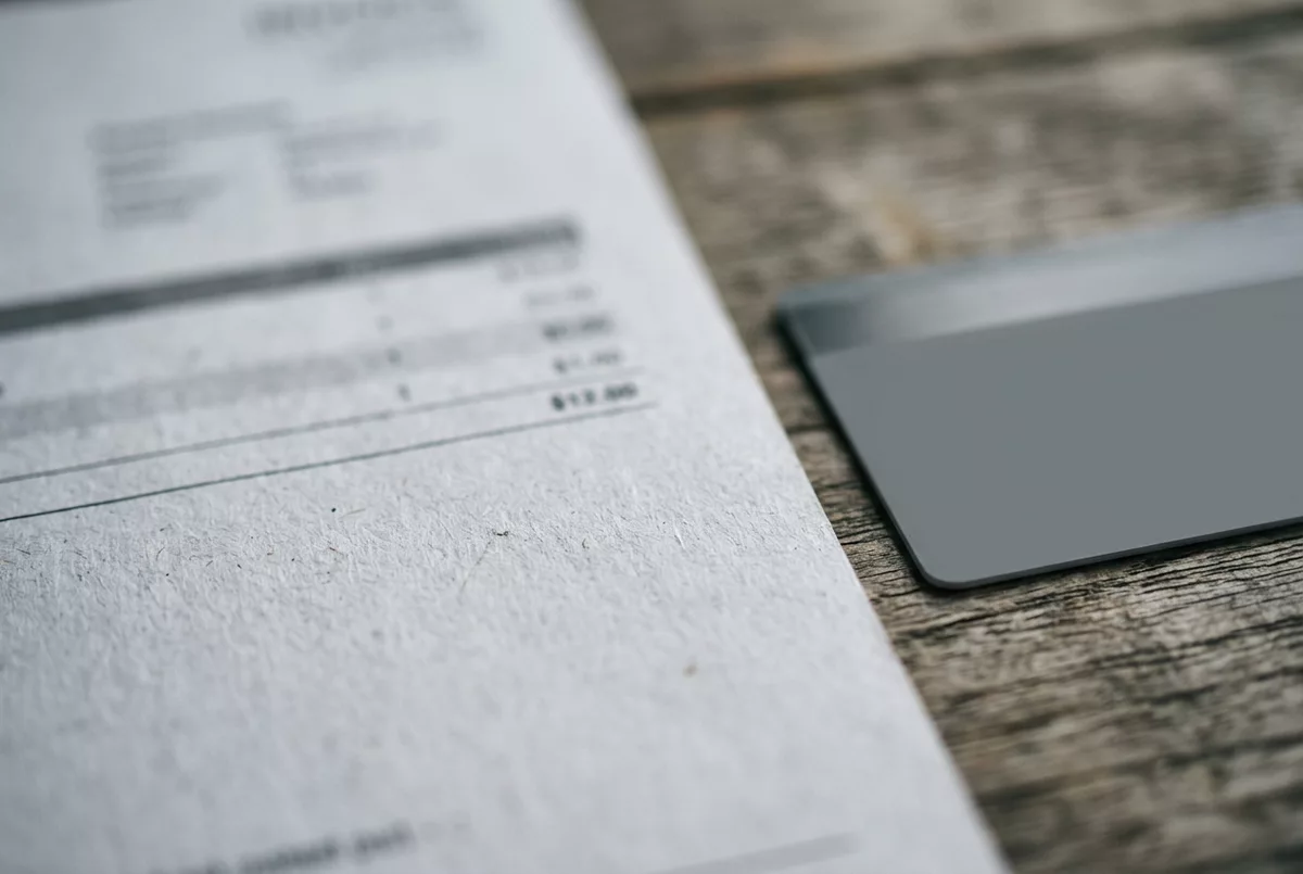Gedruckte Rechnung neben einer Bankkarte auf dem Tisch
